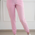 A woman wearing pink sweatpants and white sneakers.